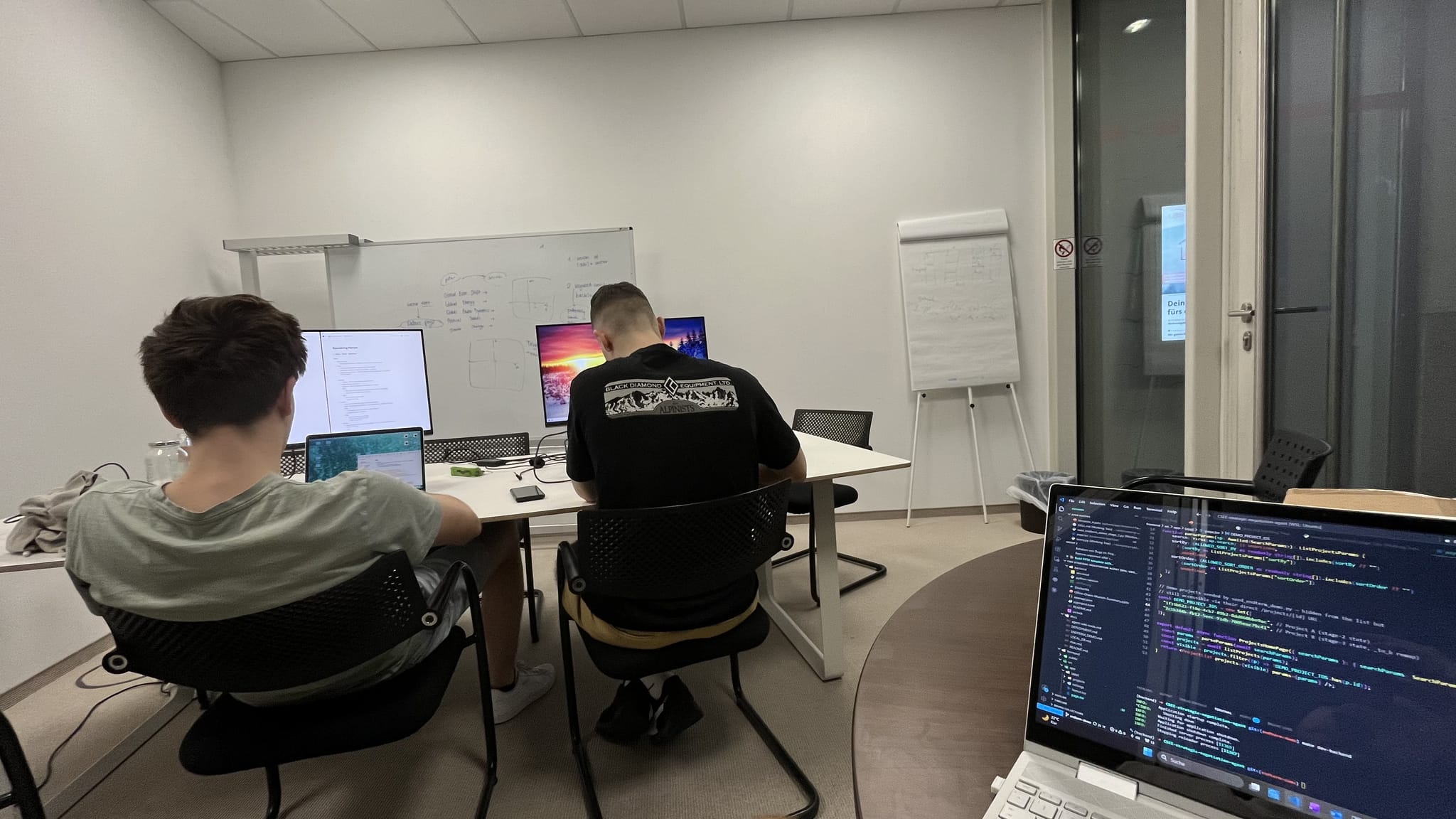 Arbeitsplatz mit mehreren Bildschirmen und Code während eines gemeinsamen Projekts